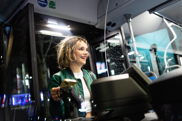 Pressefoto - digital Zahlen im Bus Eine junge Frau bezahlt die Busfahrt mit ihrem Smartphone beim Einstieg in den Bus.
