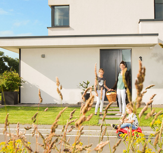 Eine sechsköpfige Familie spielt an einem sonnigen Tag vor Ihrem Haus auf der Straße und Garage